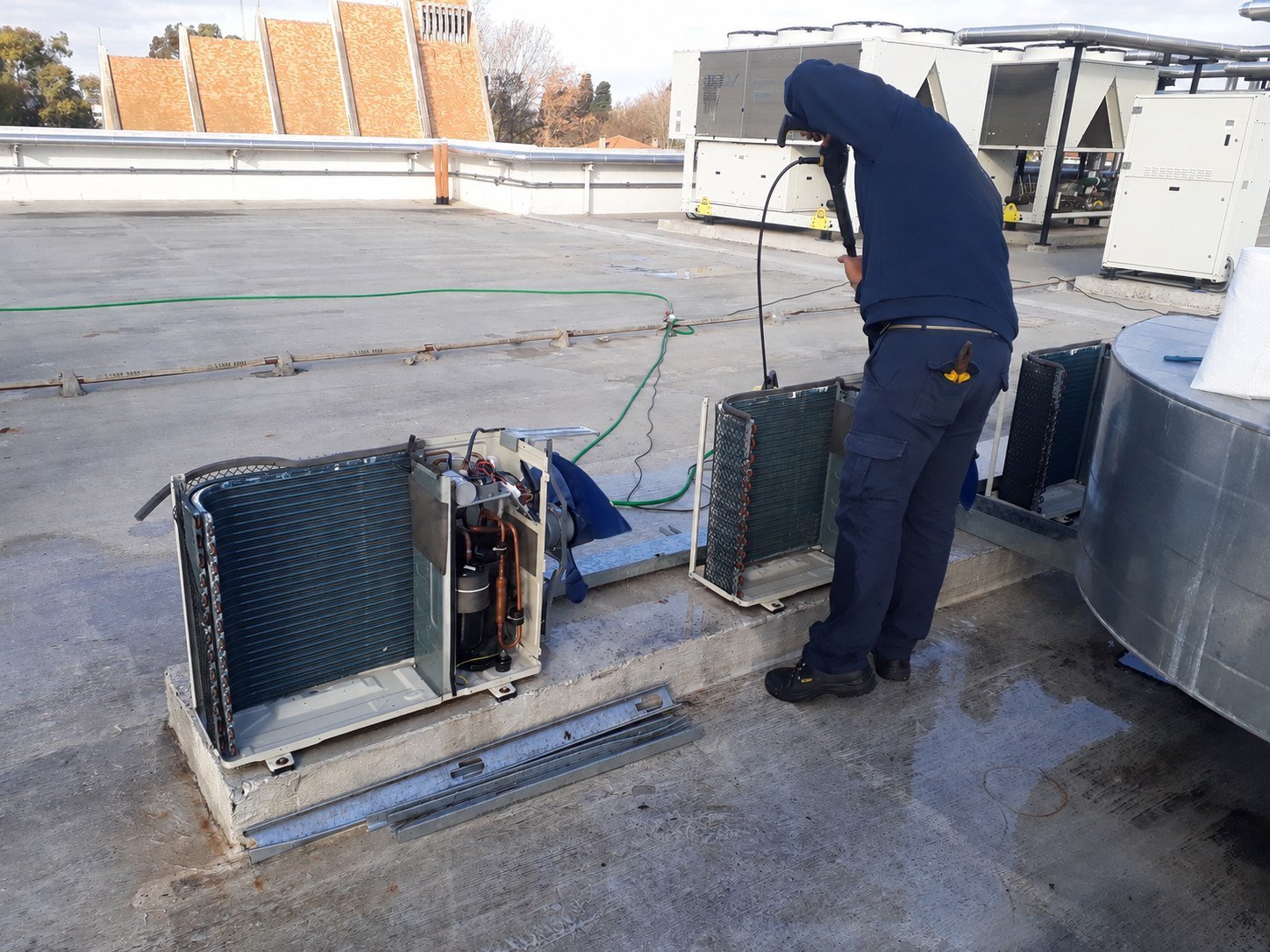 Técnico realizando hidrolavado en condensadora