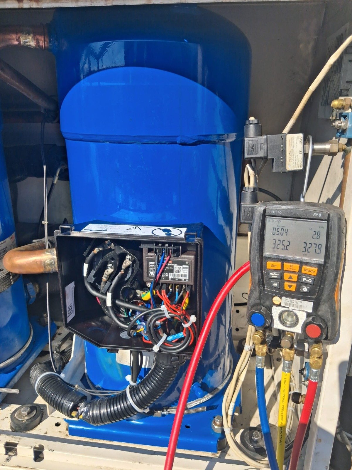 Conexión eléctrica de compresor industrial y verificación con instrumental